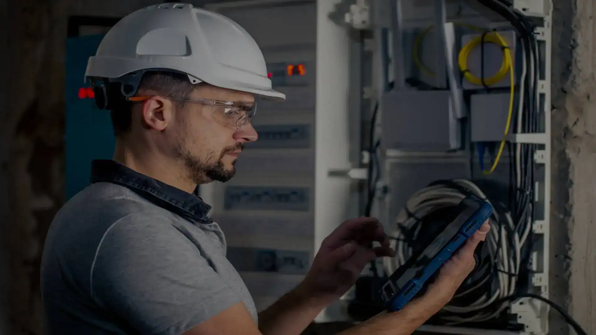Veiligheidsspecialist controleert en onderhoudt elektrische schakelkasten in een technische werkomgeving.